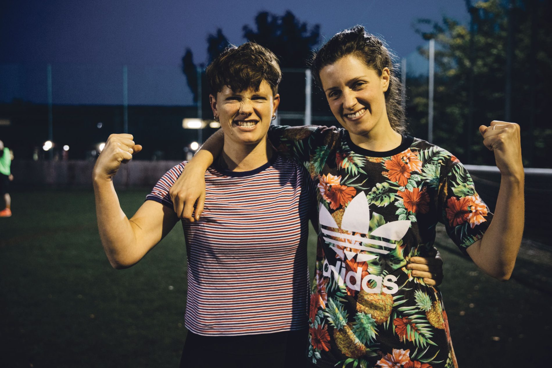Two women celebrate together and punch the air after the football match.