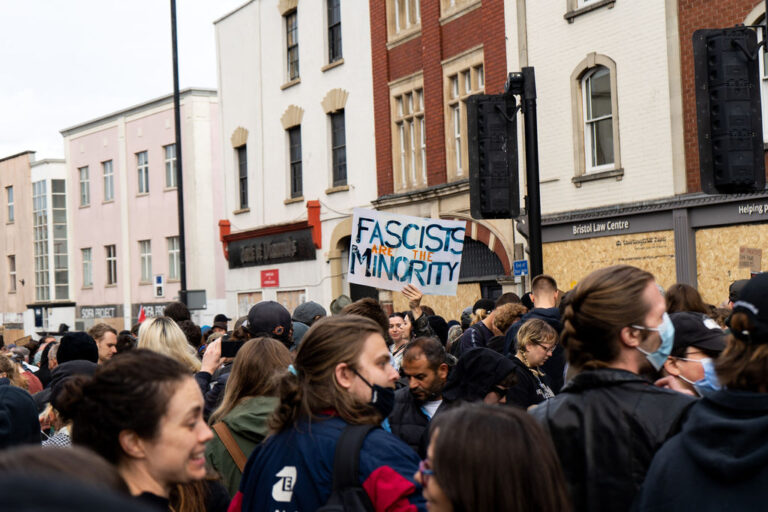 Busy crowd of counter protesters on old market, placard in the centre reads "fascists are the minority"