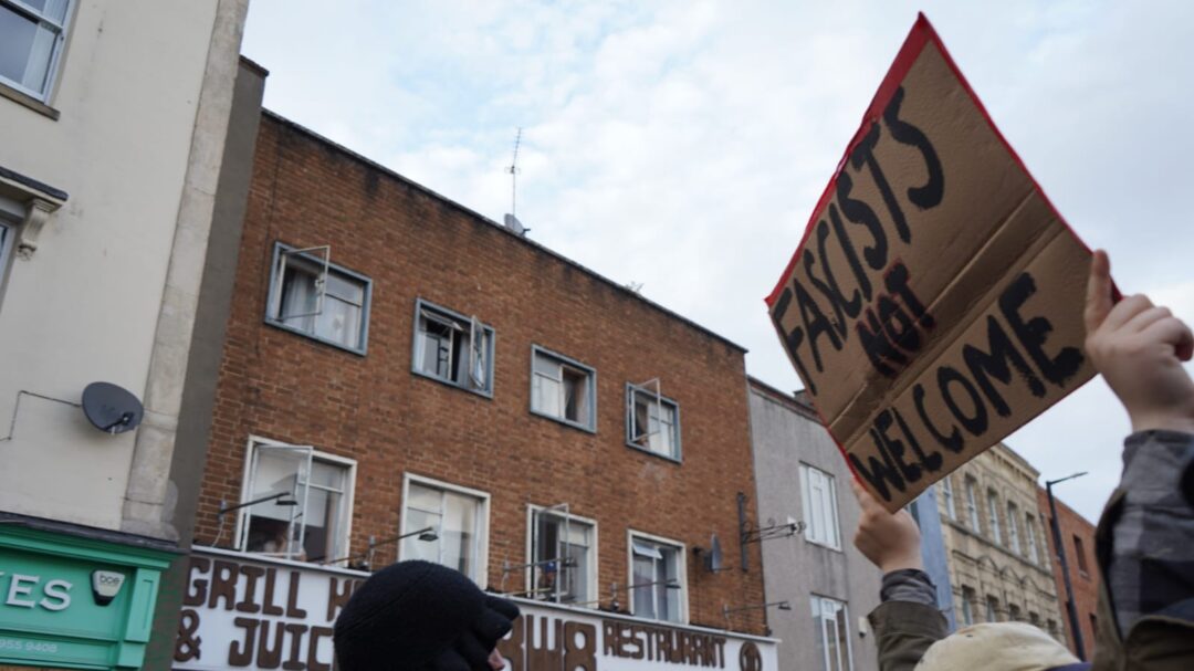 A placard is held aloft saying 'fascists are not welcome here'