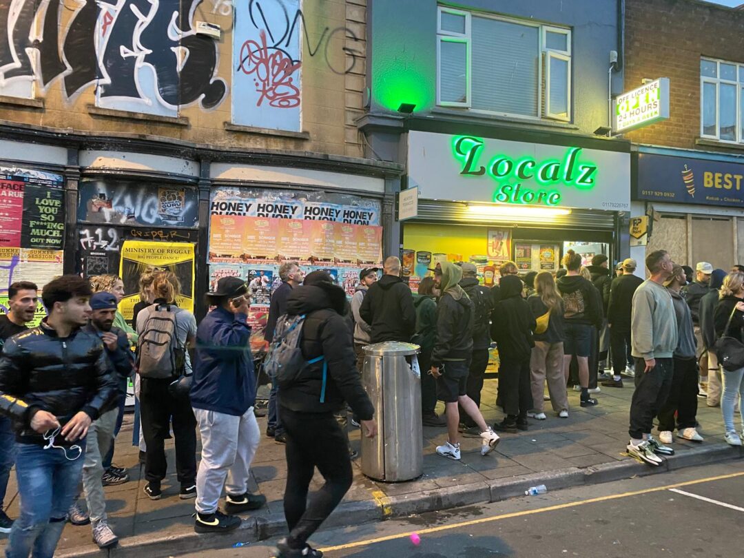 A line of people outside an off-license shop 