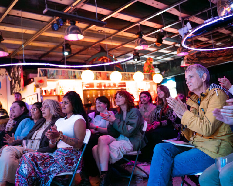 An audience of people applauding at a Cable event taking place at Strange Brew in Bristol.