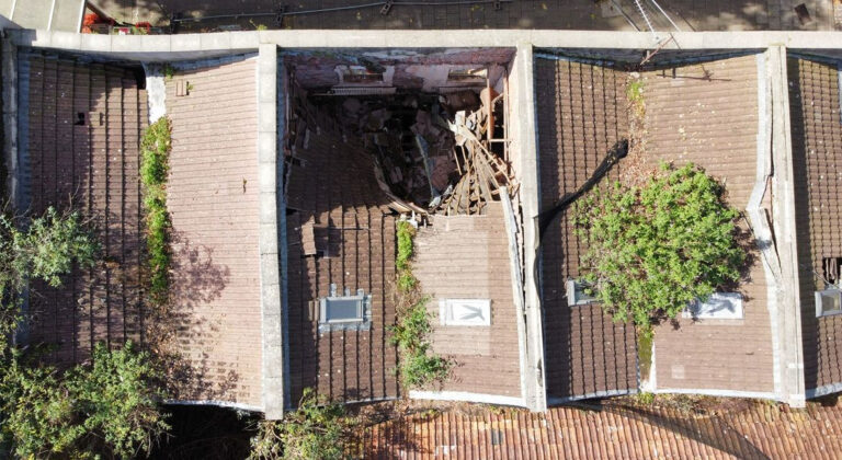 An aerial photo of a row of buildings, where one of the roofs has collapsed