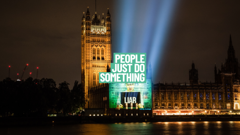 A nightime photo of the houses of parliament with the added text saying 'liar'