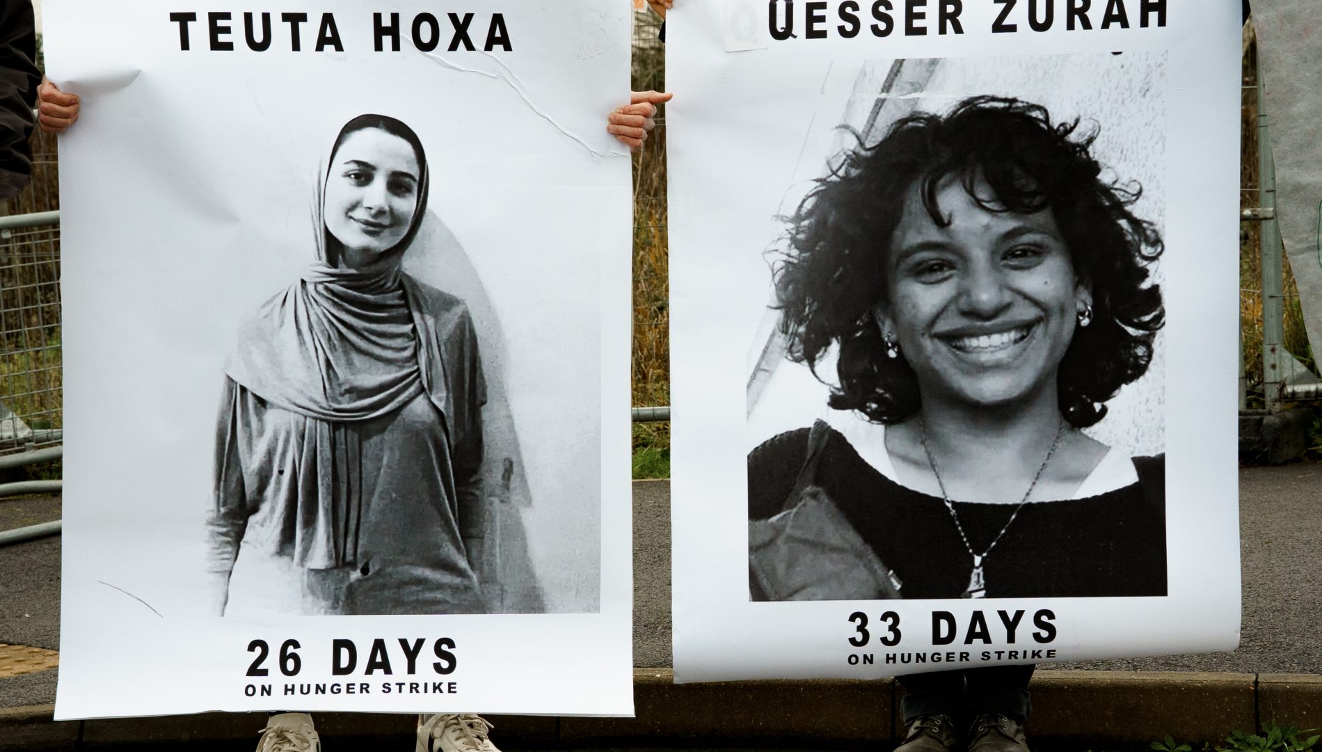 Large white banners showing the smiling faces of two women