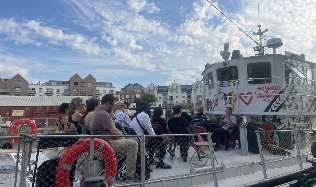 A group of people sitting on chairs on the deck of a boat